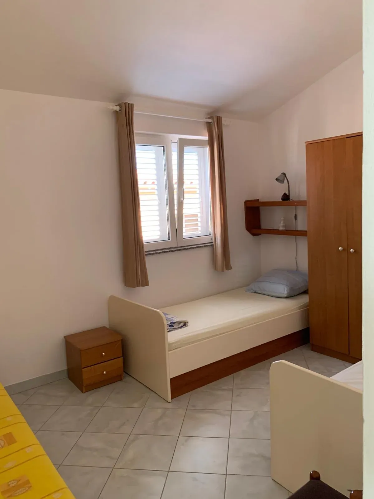 Spavaća soba s pojedinačnim krevetom uz prozor